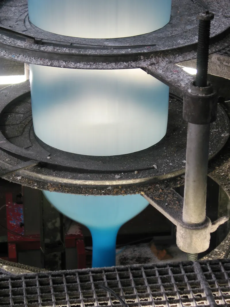 Blue film bubble rising through a blown-film extrusion line