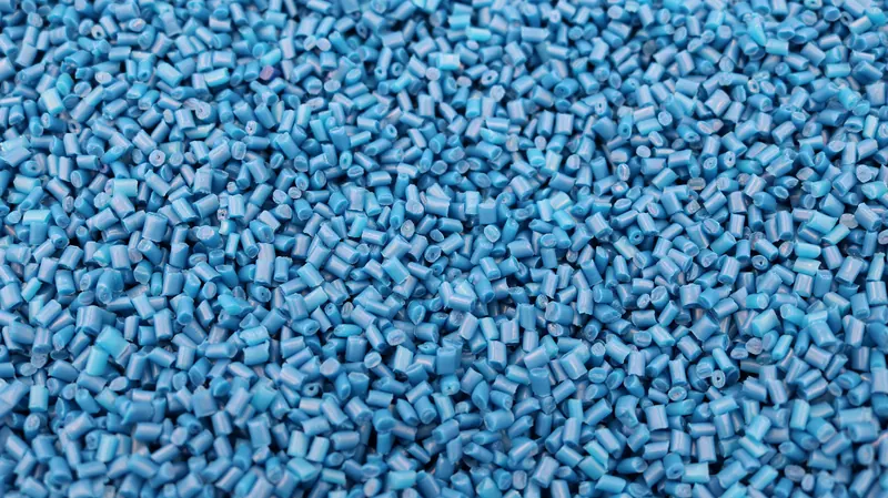Close-up of blue polymer pellets filling the frame