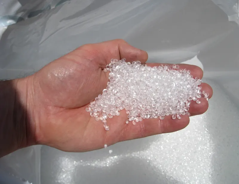 Clear polymer granules held in an open hand