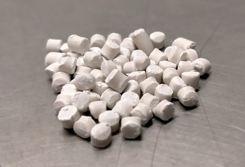 White compound pellets on a grey surface